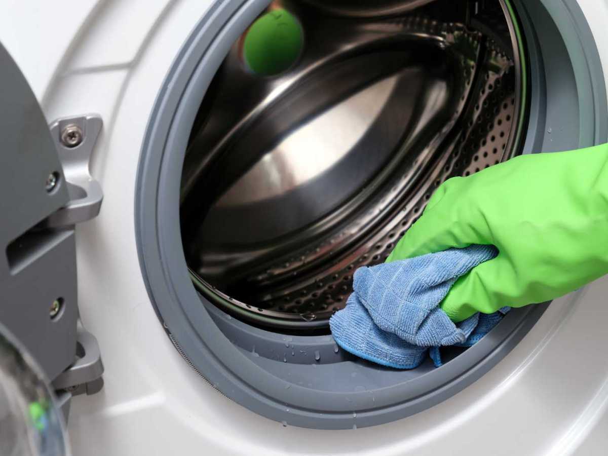 Dichtungen an der Waschmaschine werden mit einem Lappen abgewischt