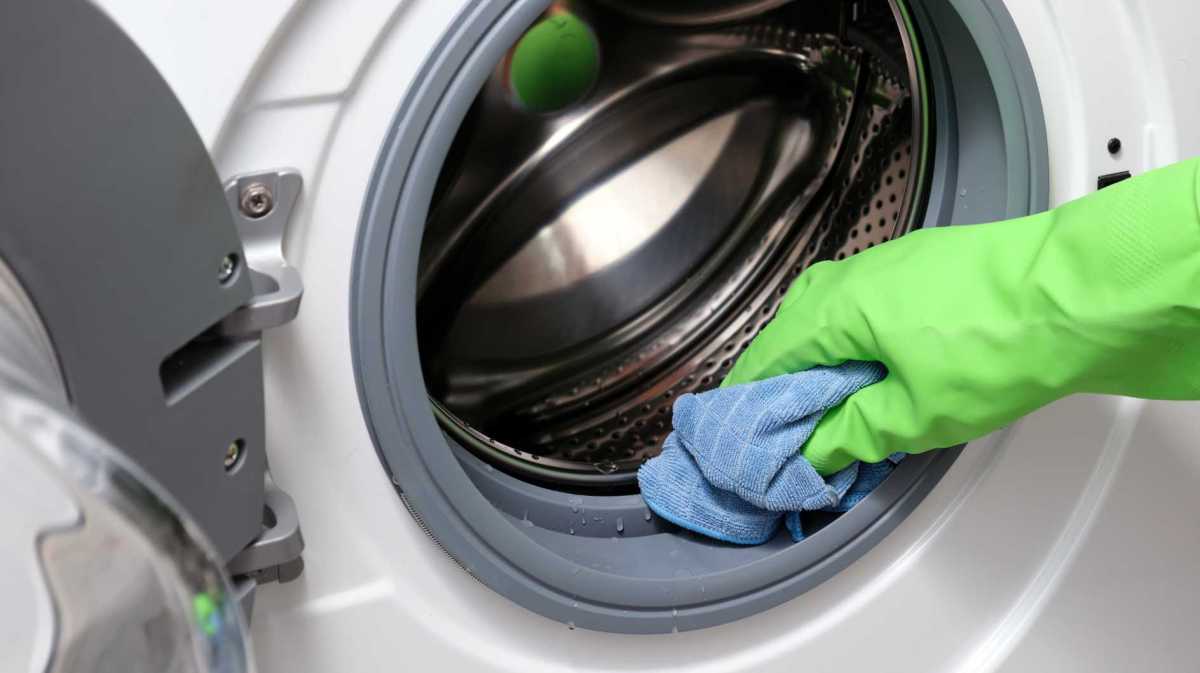 Dichtungen an der Waschmaschine werden mit einem Lappen abgewischt