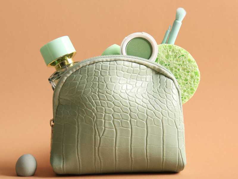 Grüne Kosmetiktasche mit Parfum und Schminke