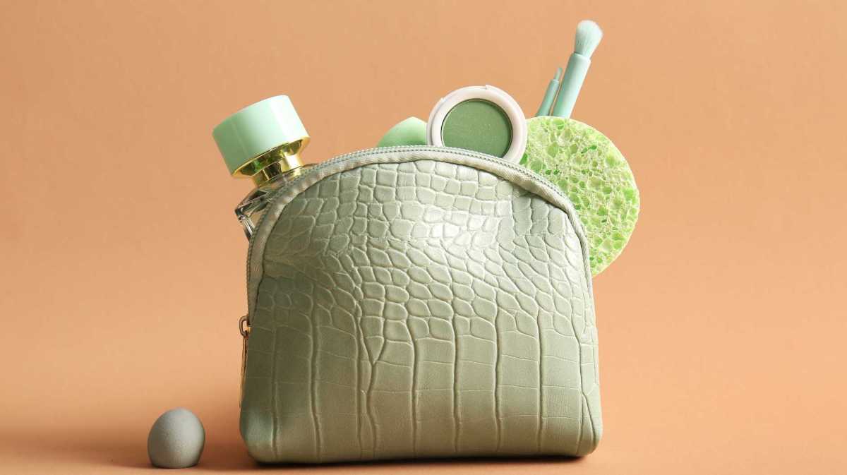 Grüne Kosmetiktasche mit Parfum und Schminke