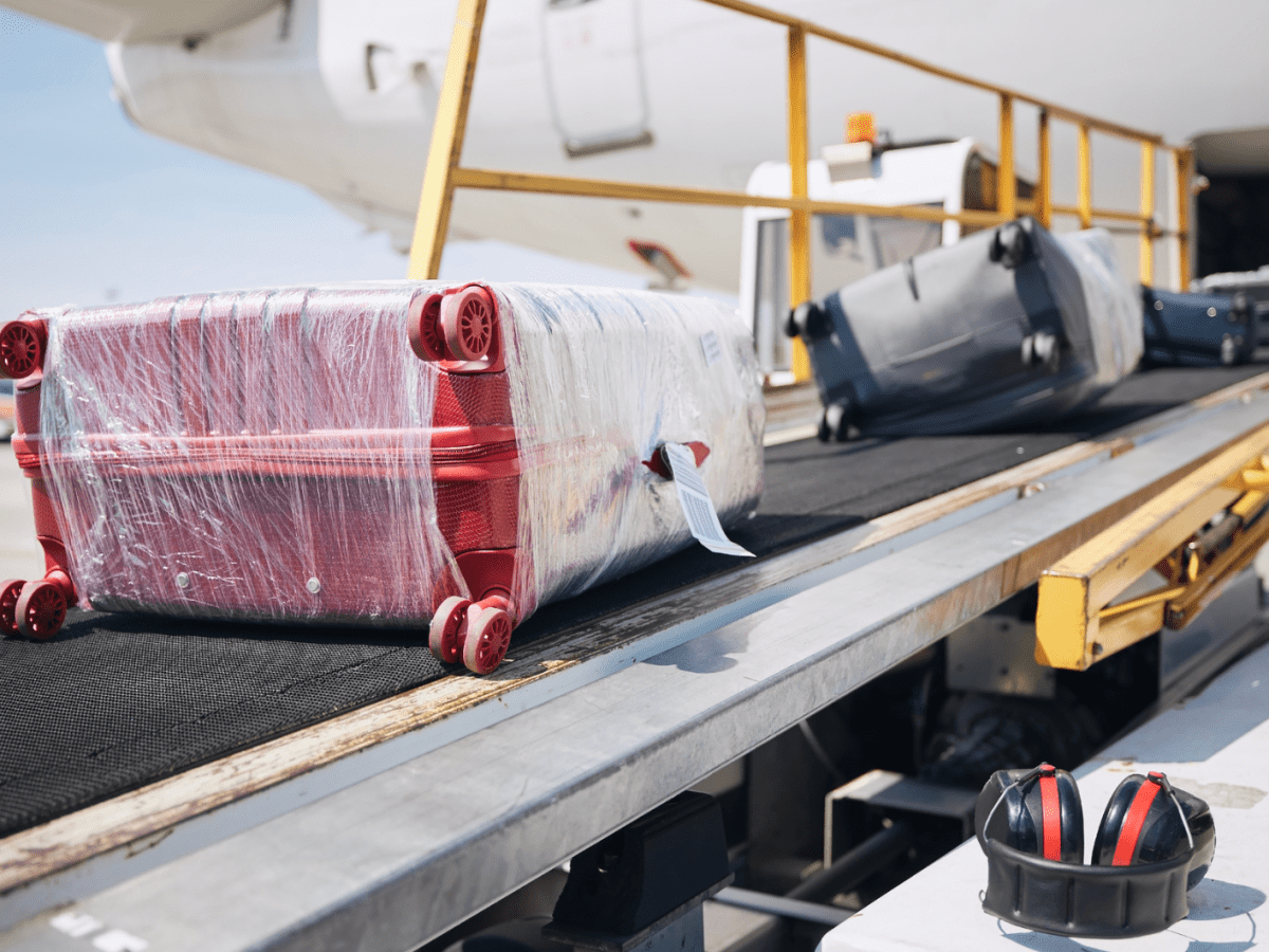 Mehrere Koffer in Folie gewickelt auf einem Gep&auml;ckband