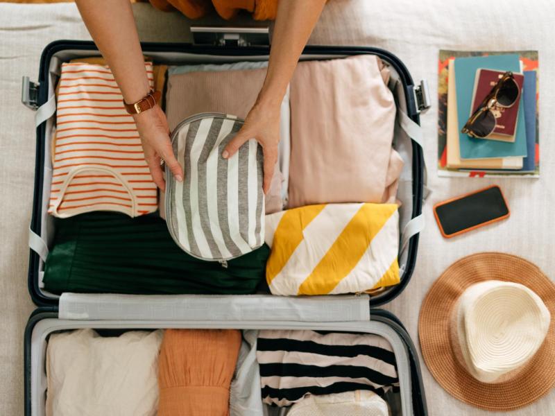 Frau packt einen Koffer für den Urlaub.