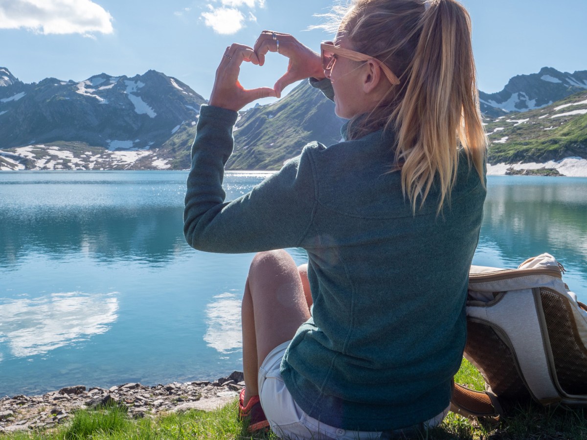 Frau sitzt auf einem Berg.