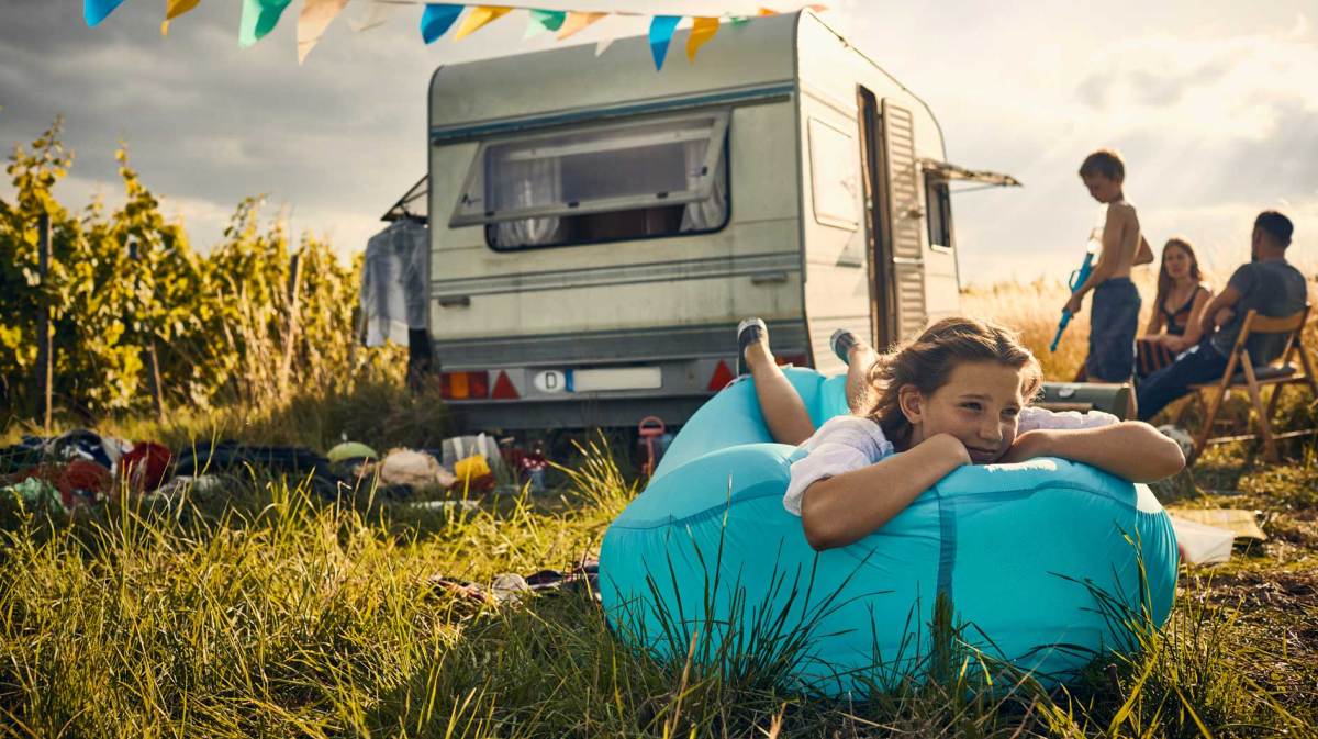 Familie beim Camping in der Wildnis mit einem Wohnwagen.