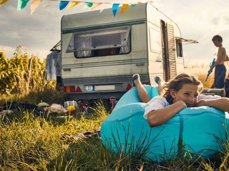 Familie beim Camping in der Wildnis mit einem Wohnwagen.