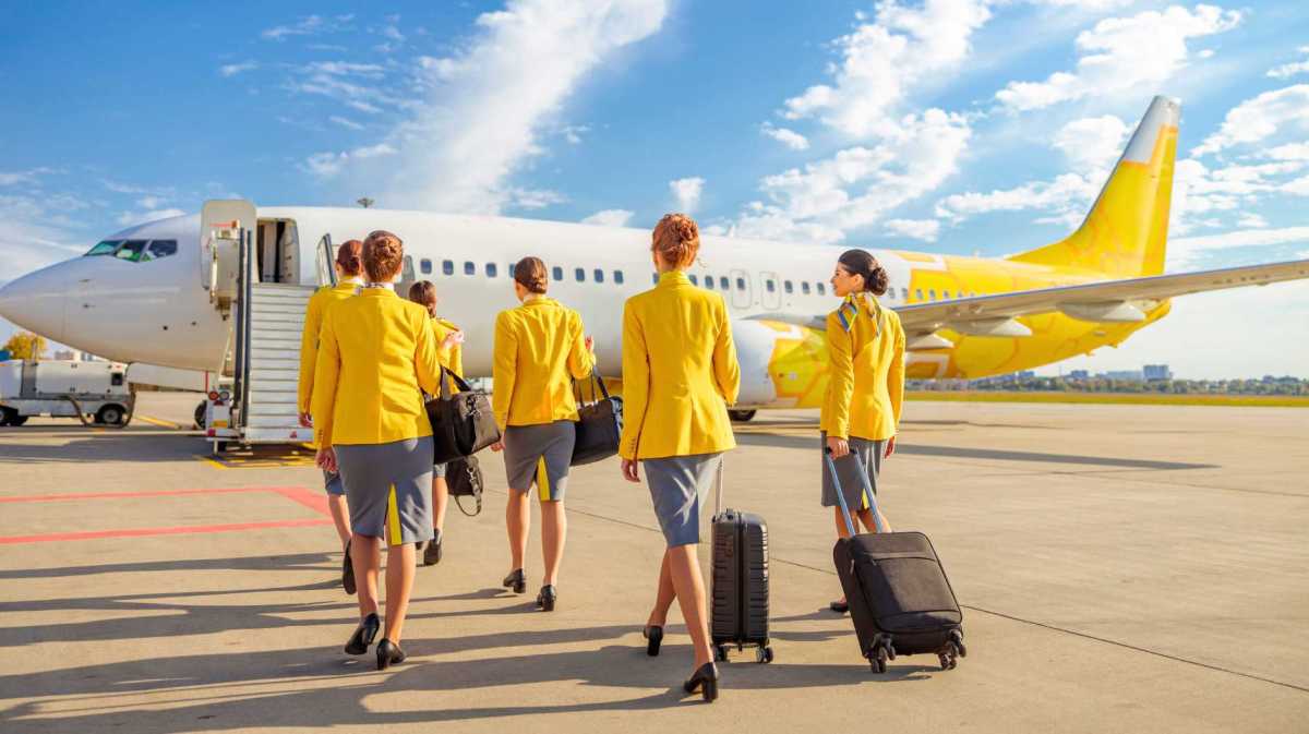 Flugbegleiterinnen auf dem Weg zum Flugzeug.