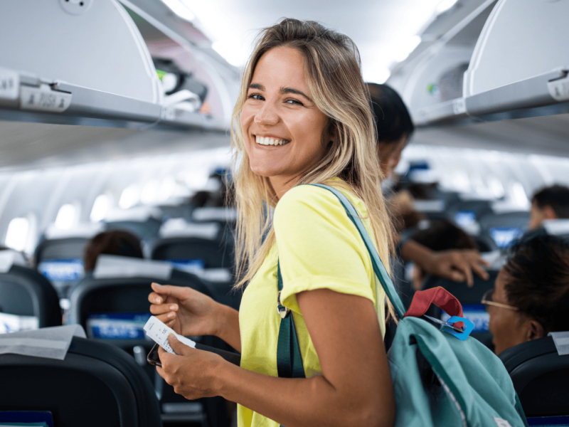 Junge Frau steht im Gang im Flugzeug.