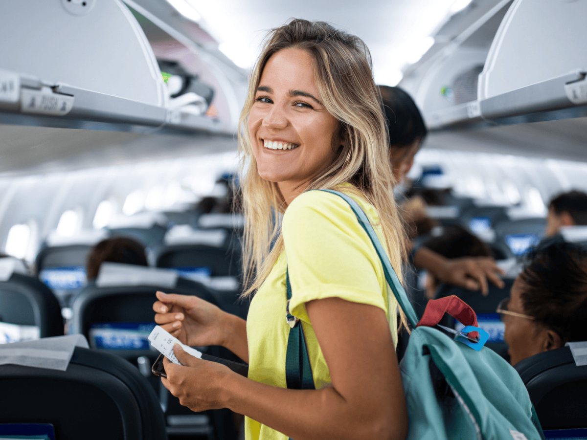 Junge Frau steht im Gang im Flugzeug.