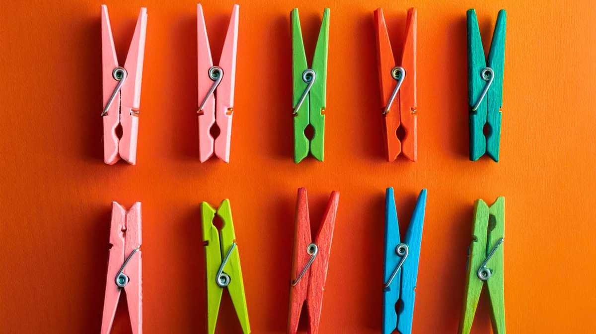 Bunte Wäscheklammern auf orangenem Hintergrund.