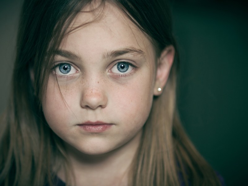 Porträt eines Mädchens, das ernst in die Kamera schaut.