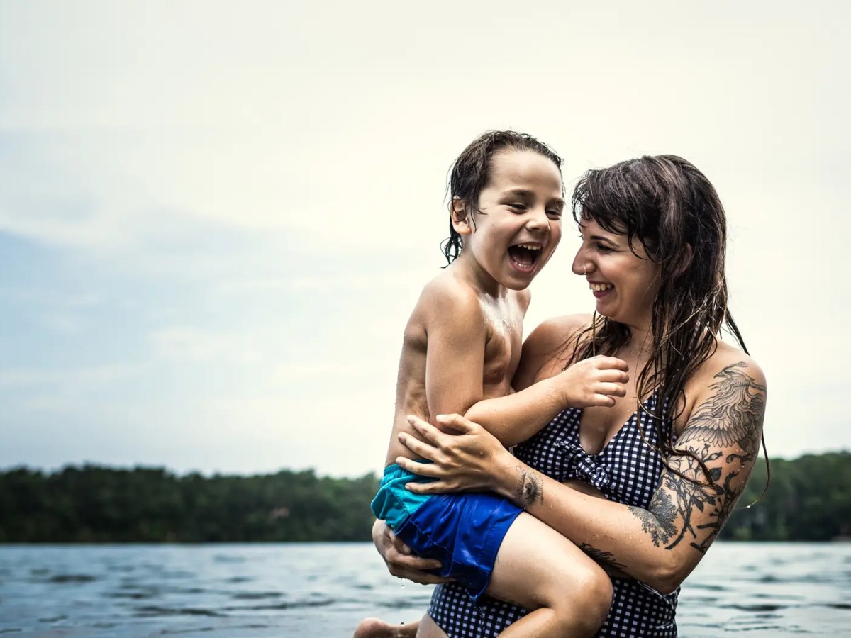 Mutter und Sohn baden im See und haben Spa&szlig;