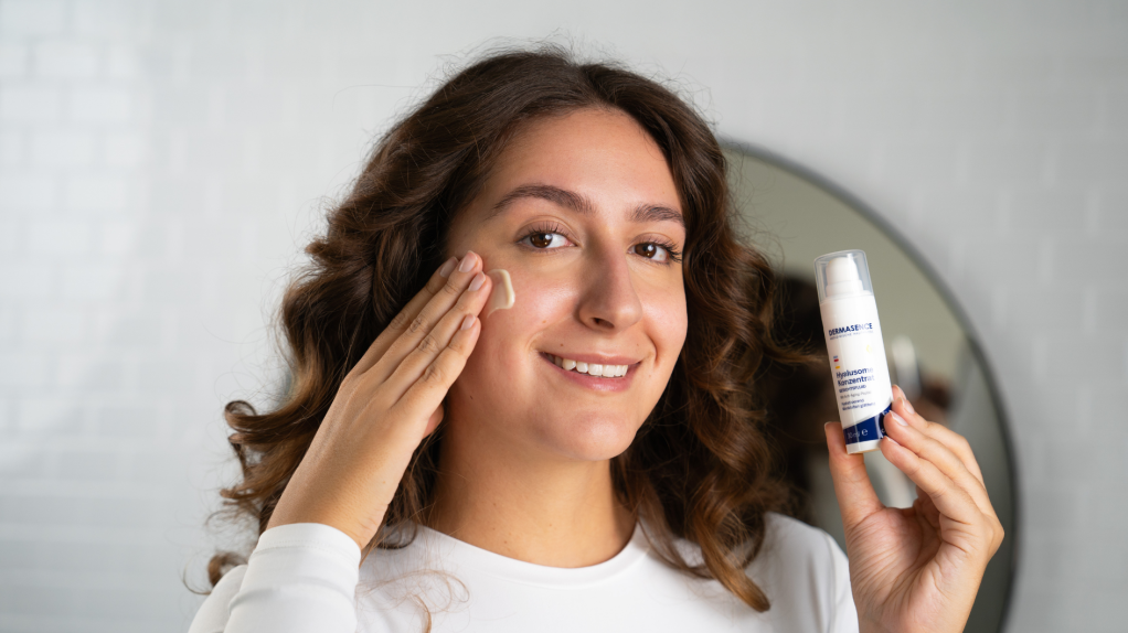 junge Frau cremt sich ihr Gesicht ein