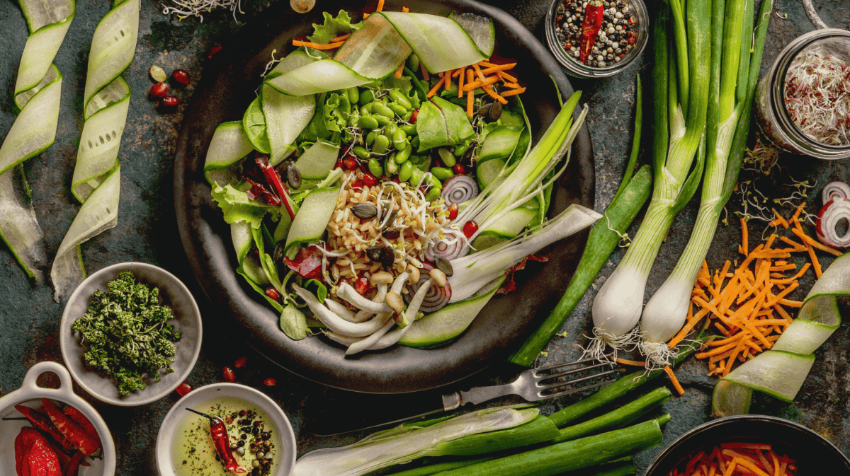 verschiedene Salate und Zutaten auf einem dunklen Tisch