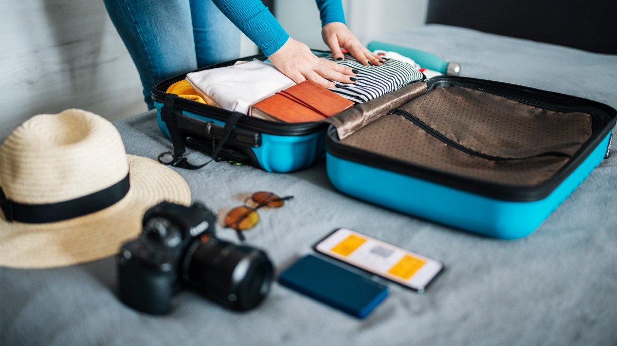 Frau beim Koffer packen und Sortieren.