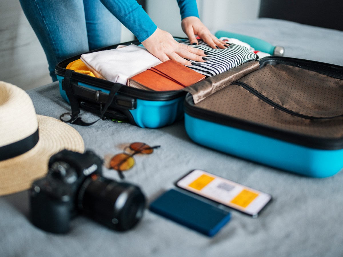 Frau beim Koffer packen und Sortieren.