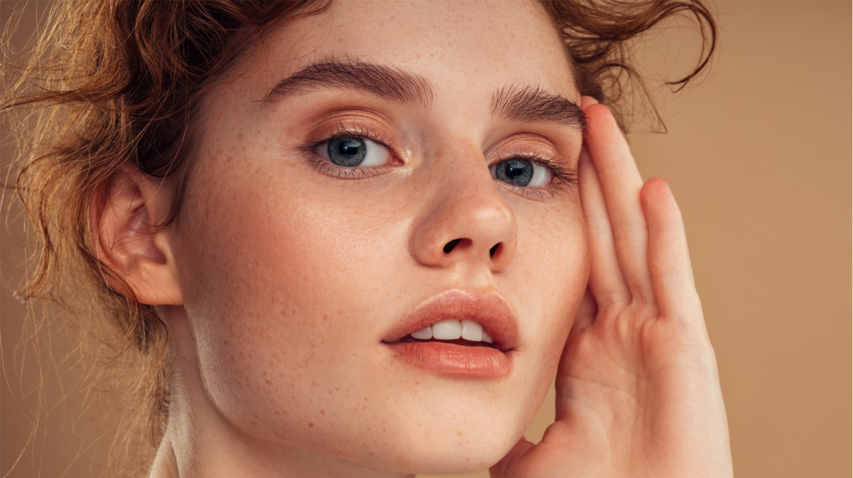 Frau mit rosigem Teint und vollen Augenbrauen.