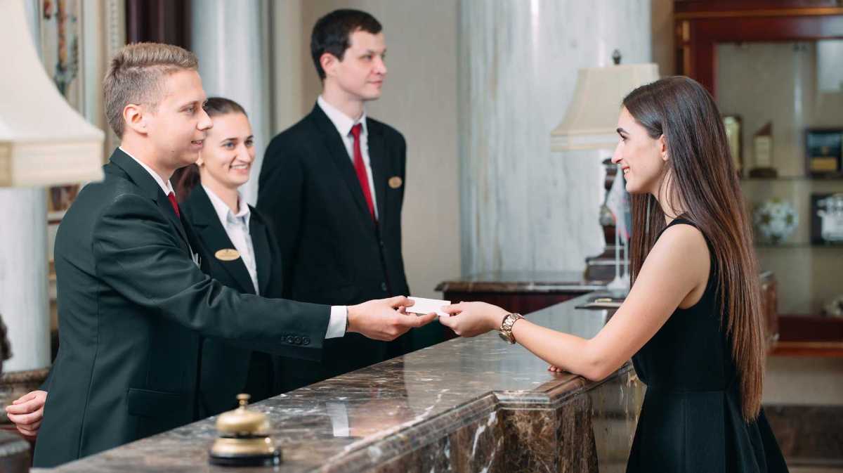 Frau checkt im Hotel ein