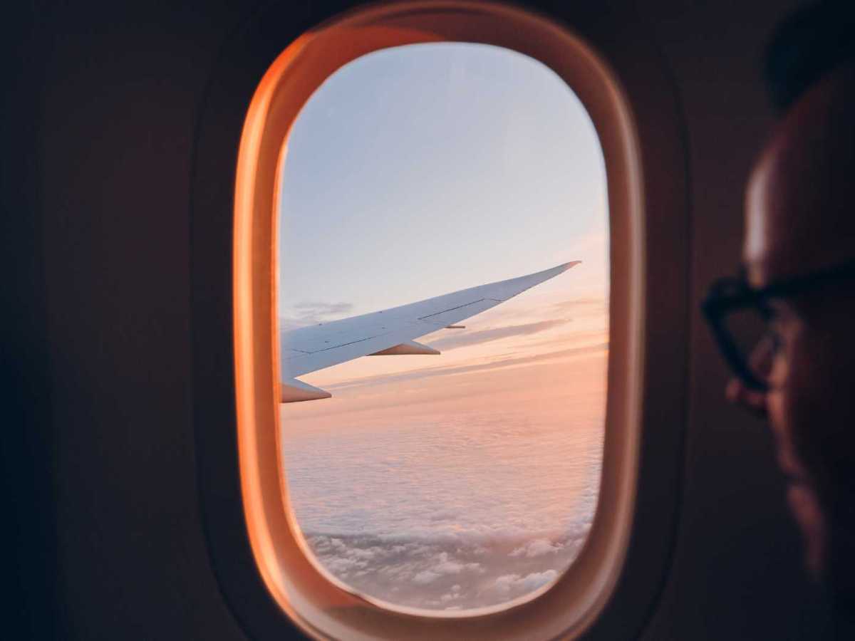 Mann schaut aus dem Flugzeugfenster