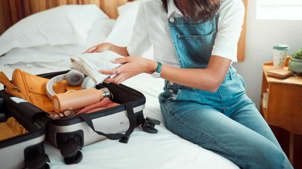 Frau packt ihren Koffer auf dem Bett