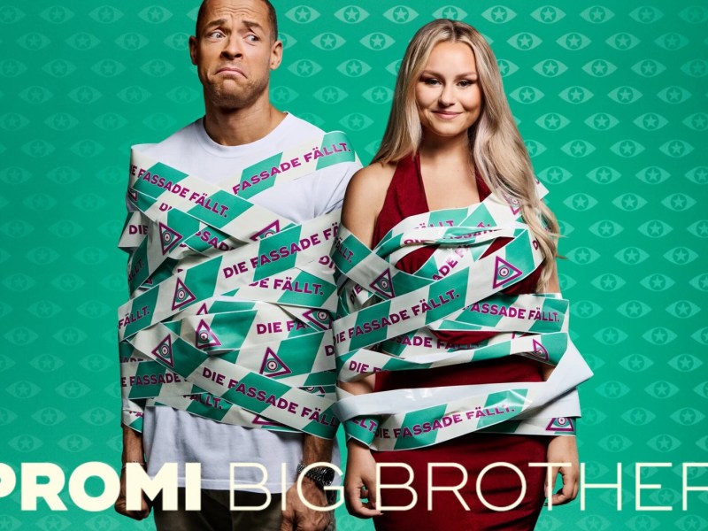 Andreij Mangold und Sara Jane Wollny in grünem Absperrband gewickelt vor dem Promin Big Brother Hintergrund