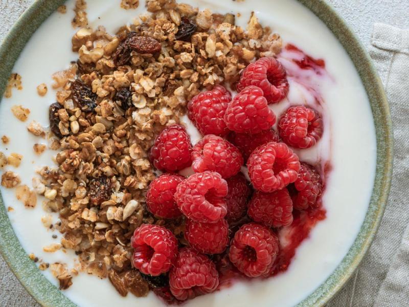 Bowl mit Skyr oder Joghurt und Granola und Himbeeren.