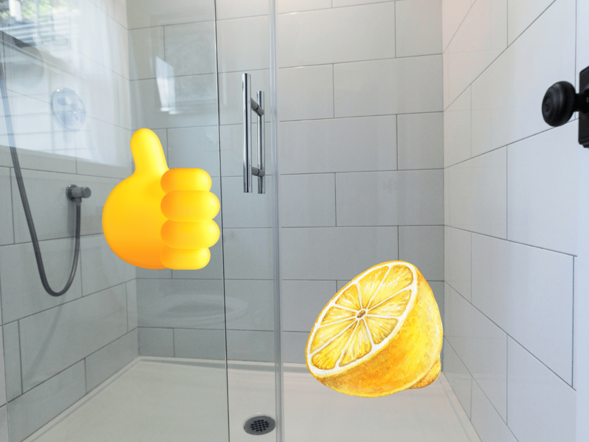 Helle geflieste Duschkabine mit Glaswand, Zitronenh&auml;lfte und Daumen-hoch-Emoji als Symbol f&uuml;r nat&uuml;rliche Reinigung.