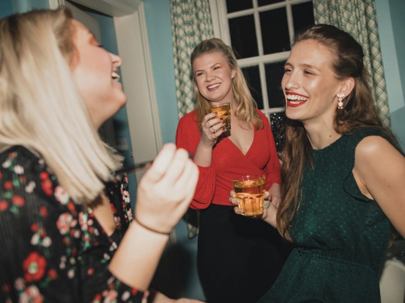 Drei Freundinnen lachen und machen sich im Badezimmer fertig