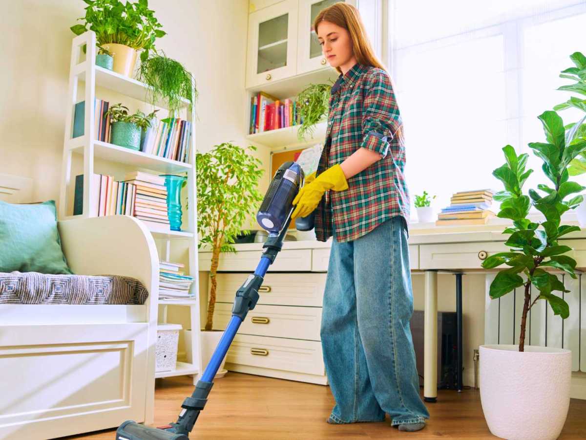 Frau saugt ihr Schlafzimmer.