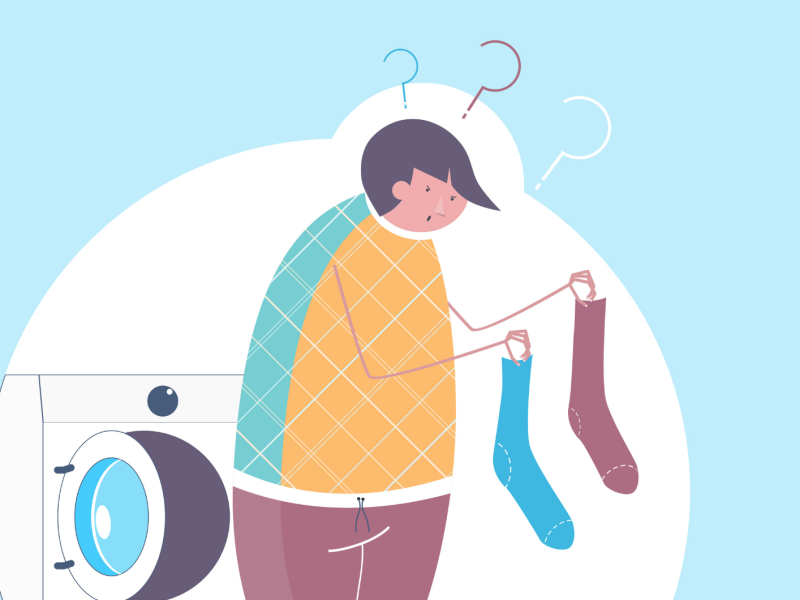 Zeichnung einer Jungen Person mit schiefer Frisur vergleicht zweifelnd eine blaue und eine braune Socke vor geöffneter Waschmaschine.