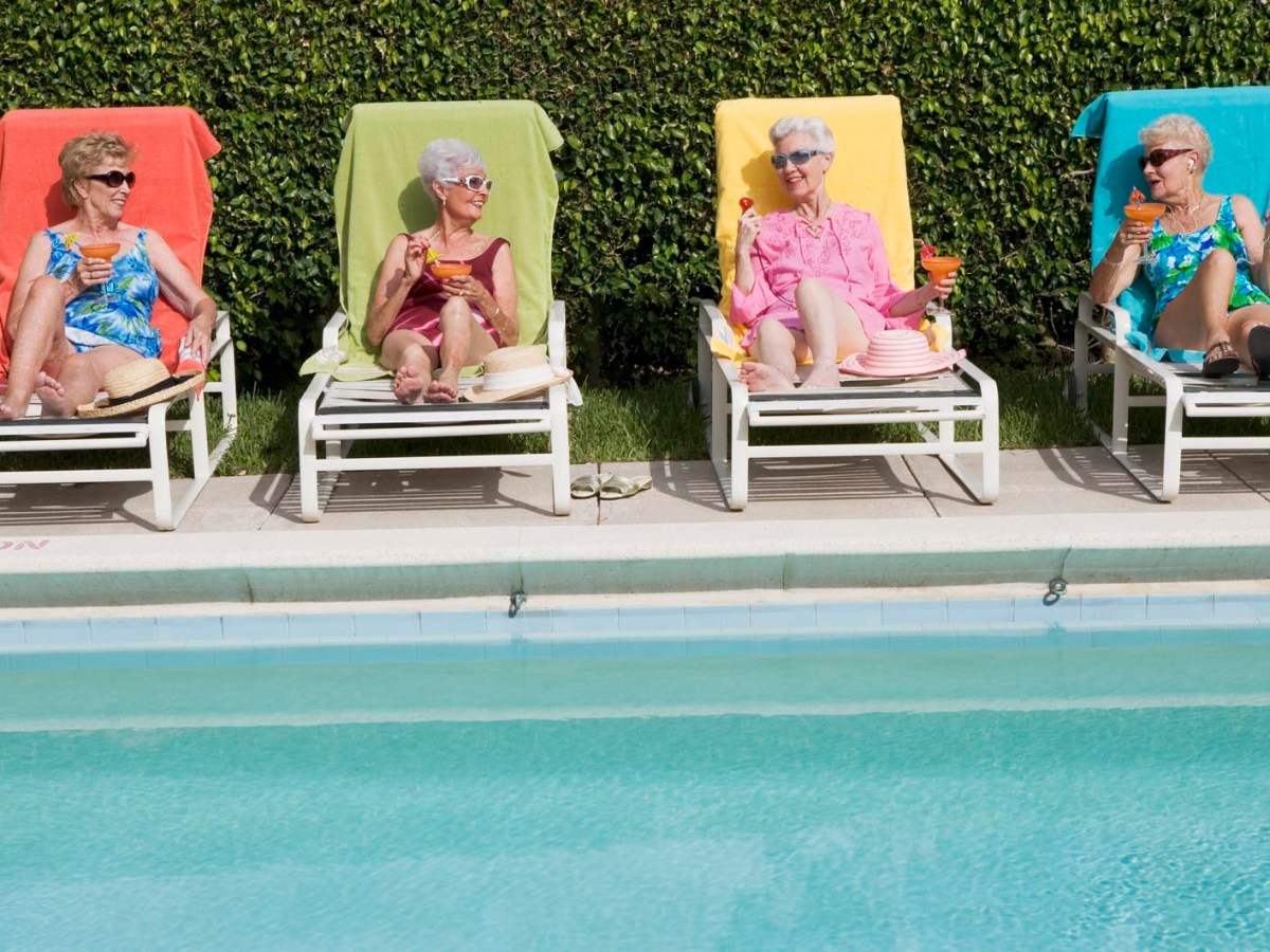 Seniorinnen liegen im Sommer an einem Pool
