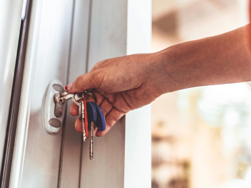 Frau sperrt Haustüre zu