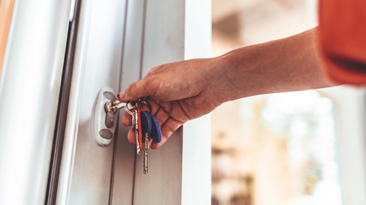 Frau sperrt Haustüre zu