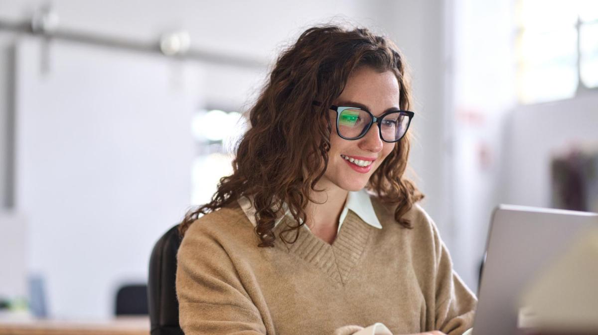 Junge Frau mit dunklen Locken und Brille.