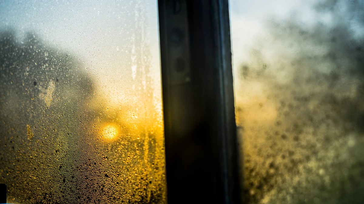 Beschlagene Fensterscheibe mit Abendsonne im Hintergrund