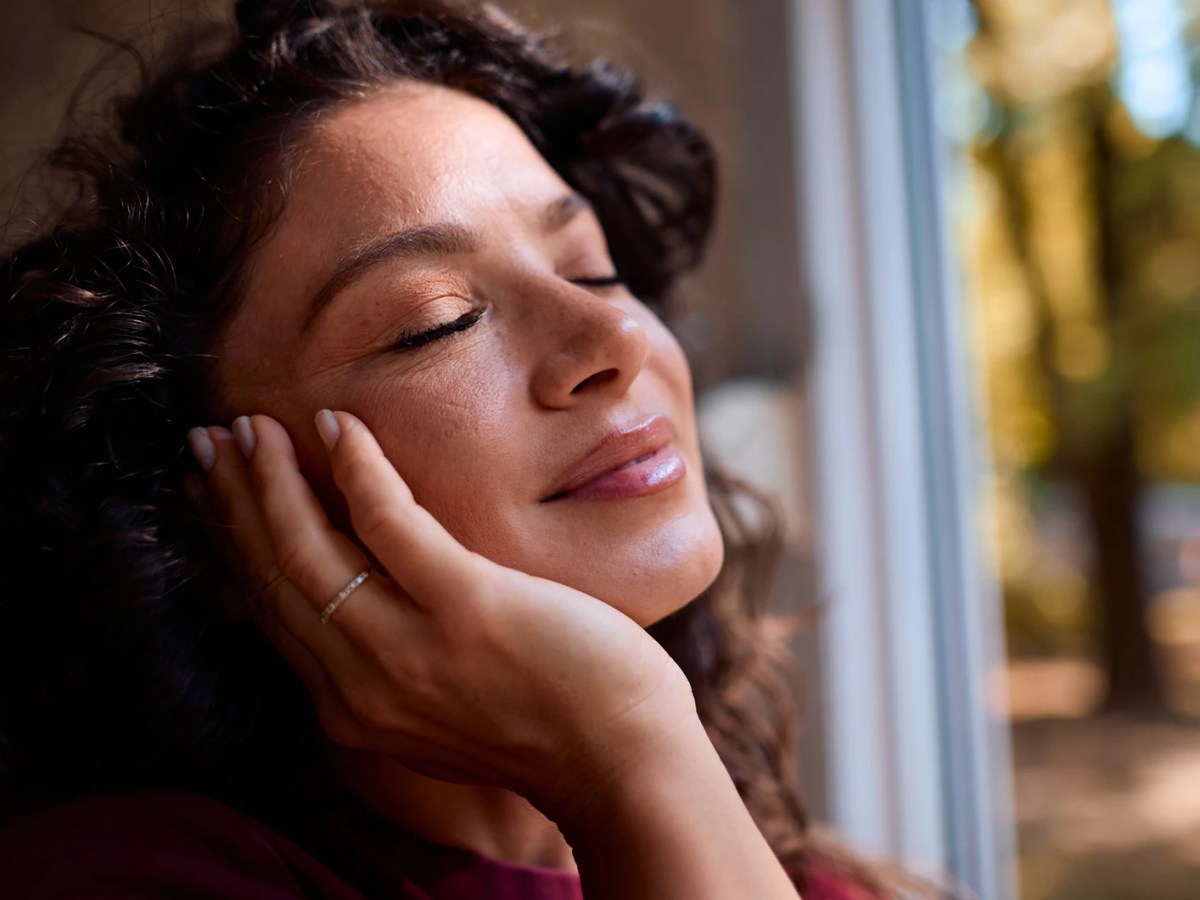 Frau mit reiner Haut, im Hintergrund herbstliche B&auml;ume zu sehen