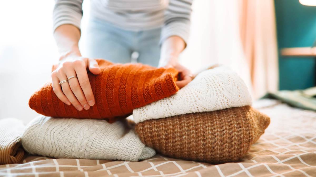 Frau legt Pullover zusammen