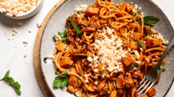 Spaghetti mit Kürbis-Bolognese auf hellem Teller.