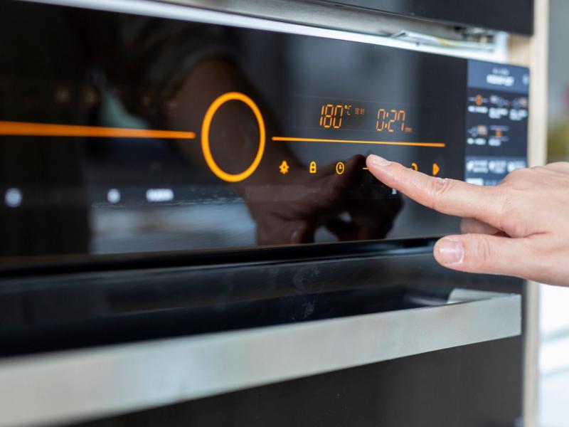 Frau stellt Backofen ein.