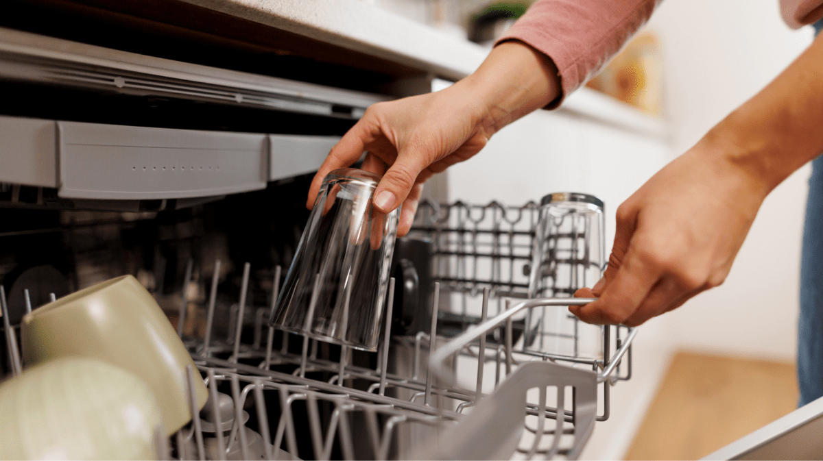 Frau räumt Geschirr ein.