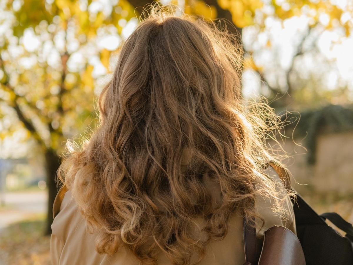 Leicht gewellte und lockige Haare einer Frau von hinten.
