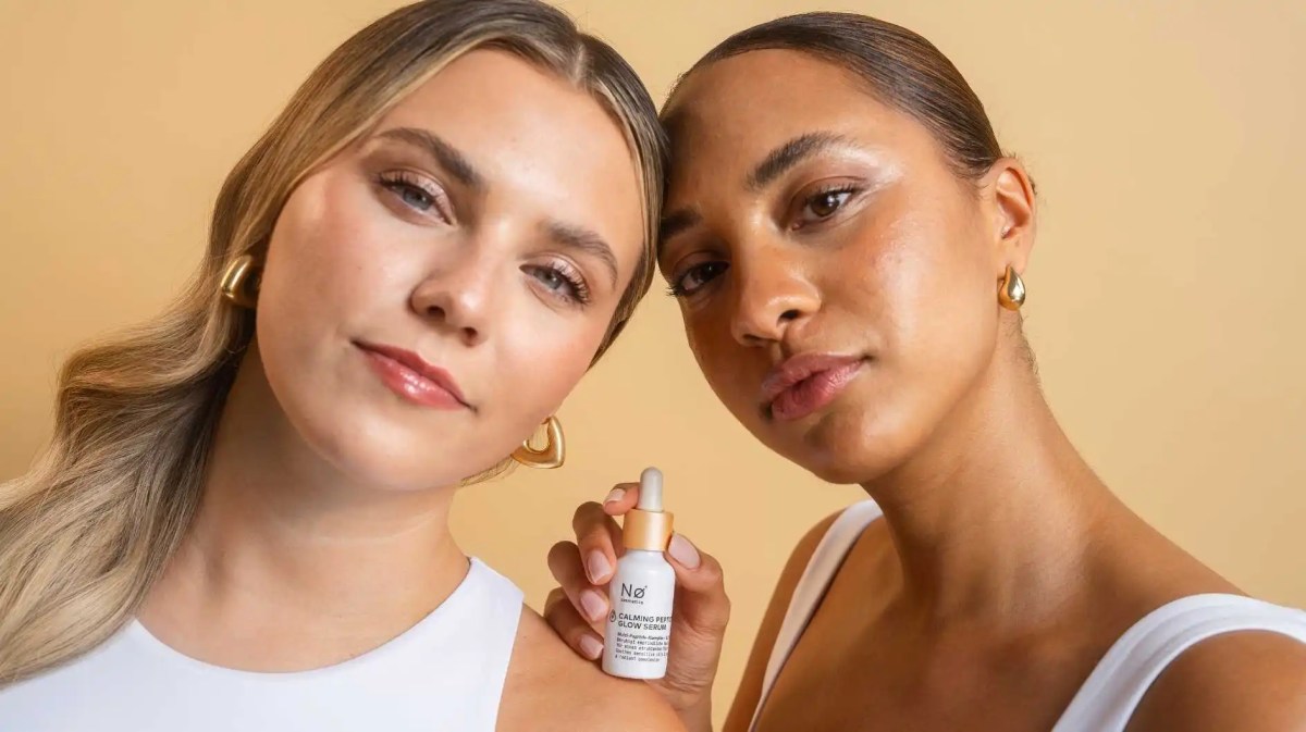 Caroline R. Kroll und eine Frau halten ein neues Serum in der Hand