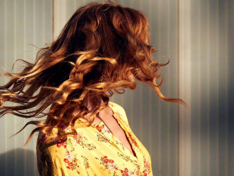 Frau mit roten Locken im Wind.