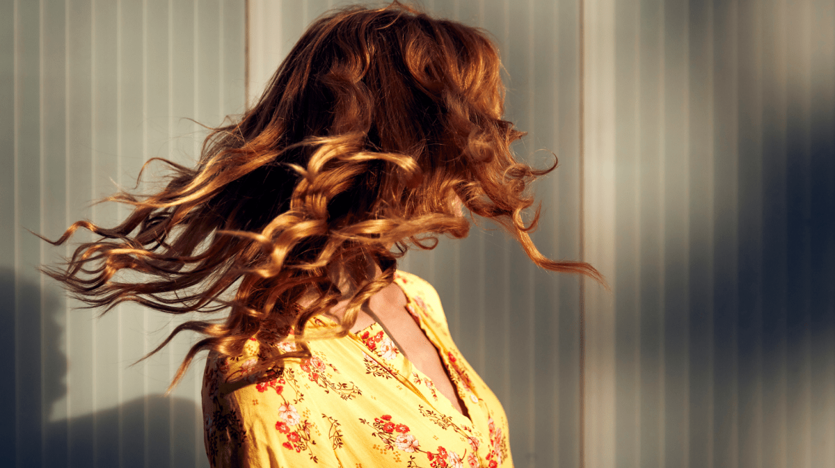 Frau mit roten Locken im Wind.