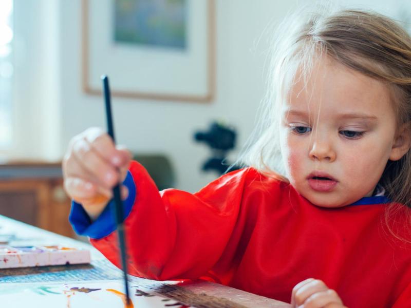 Kleines Mädchen mal mit einem Pinsel.