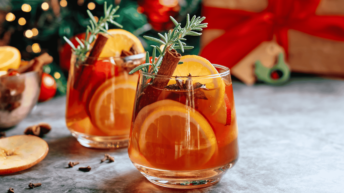 Winterliche Sangria mit Zimtstangen, Orangen und Rosmarin.