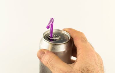 Hand an Getr&auml;nkedose, bei der in Lasche ein pinker Strohhalm steckt