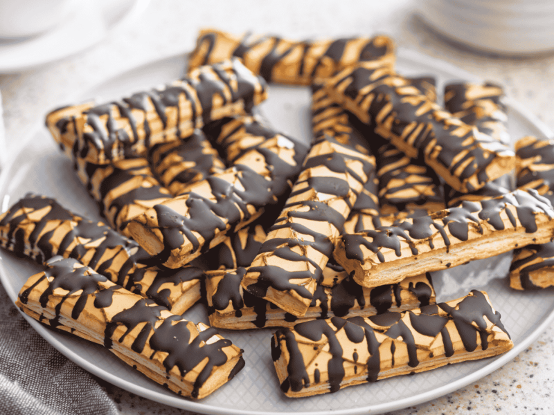 Sfogliatine glassate mit Schokoladen-Glasur auf einem Teller.