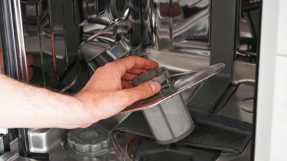 Frau entnimmt den Spülmaschinen-Filter.