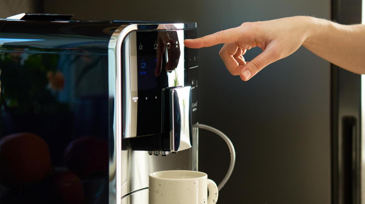 Person macht sich einen Kaffee mit einem Vollautomaten.