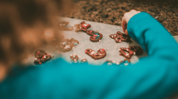 Kind dekoriert Schoko-Brezel-Pl&auml;tzchen.